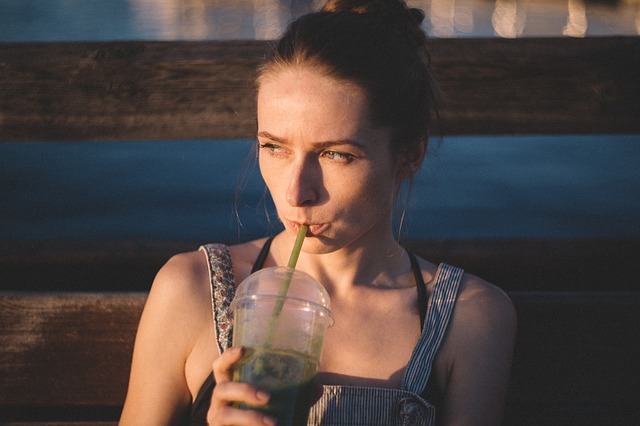緑色の飲み物を飲む女性