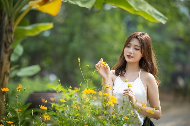 黄色い花を触る女性